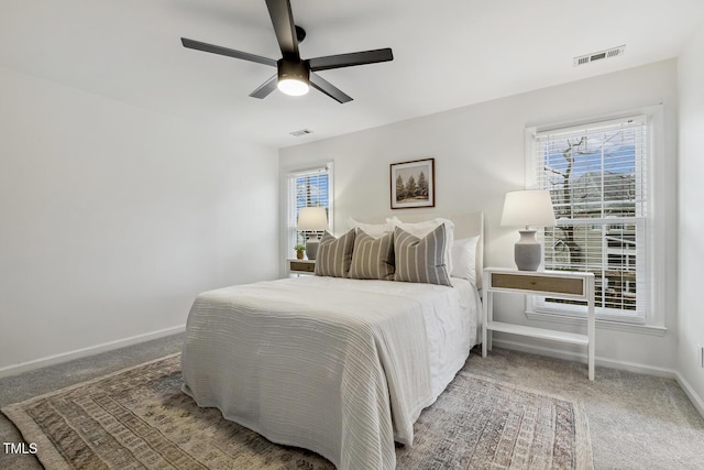 bedroom with multiple windows, ceiling fan, and carpet