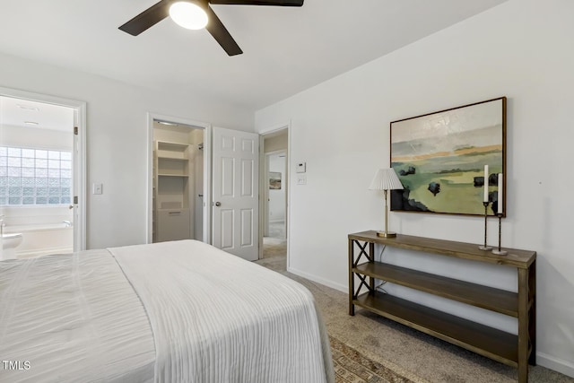 bedroom with a walk in closet, ensuite bath, carpet floors, and ceiling fan