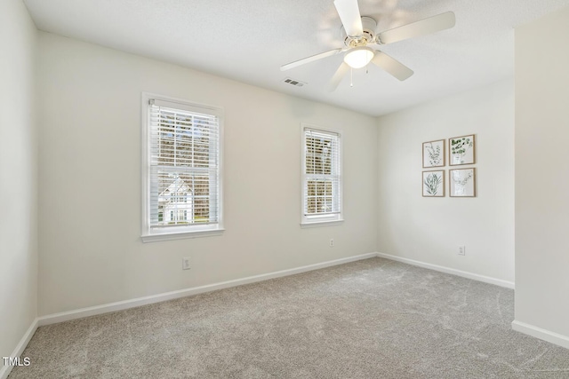 carpeted spare room featuring ceiling fan