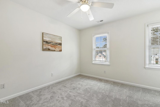 empty room with carpet flooring, a wealth of natural light, and ceiling fan