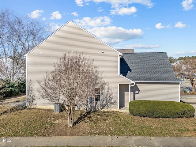 view of home's exterior featuring roof with shingles and a lawn