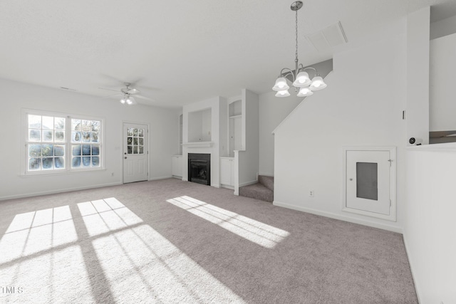 unfurnished living room with a fireplace, light colored carpet, visible vents, baseboards, and ceiling fan with notable chandelier