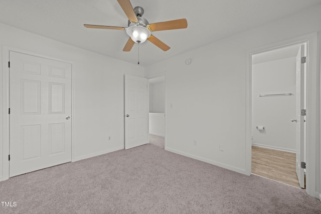 unfurnished bedroom featuring baseboards, ceiling fan, and light colored carpet