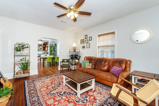 living room with dark hardwood / wood-style flooring and ceiling fan