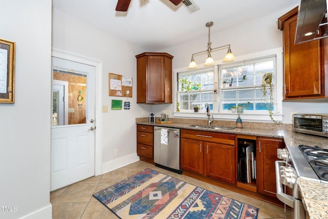 kitchen with decorative light fixtures, sink, light tile patterned floors, light stone counters, and stainless steel appliances