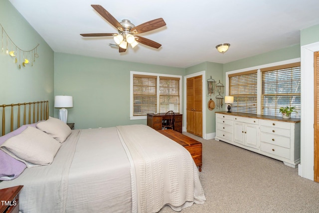 bedroom featuring multiple windows, light colored carpet, and ceiling fan