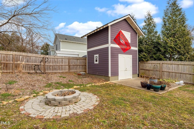 view of outbuilding with a fire pit and a lawn