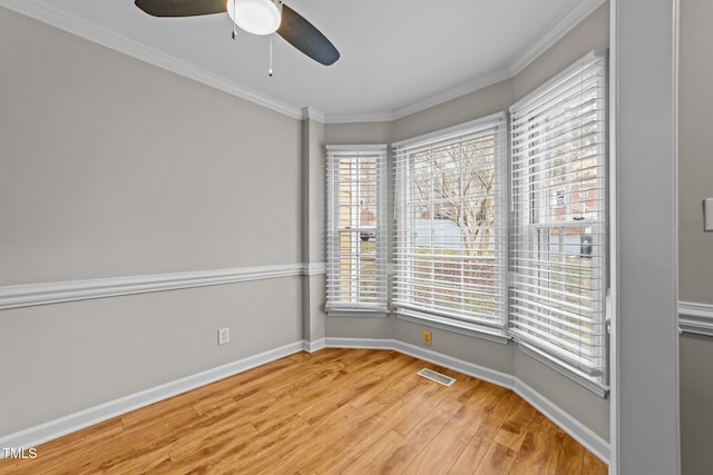 spare room featuring hardwood / wood-style floors, crown molding, and ceiling fan