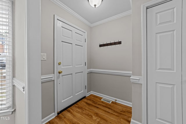 doorway featuring ornamental molding, wood-type flooring, and a wealth of natural light