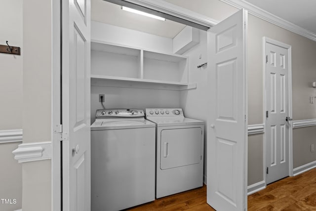 washroom featuring wood-type flooring, separate washer and dryer, and crown molding