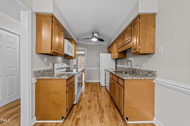 kitchen featuring white appliances, ornamental molding, sink, and light wood-type flooring