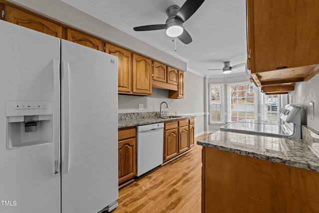 kitchen featuring crown molding, white appliances, sink, and stone counters