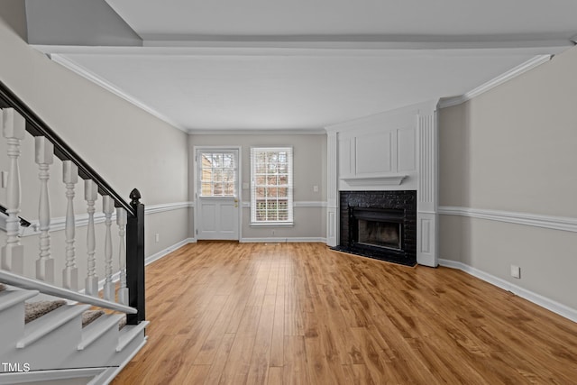 unfurnished living room featuring ornamental molding and light hardwood / wood-style flooring