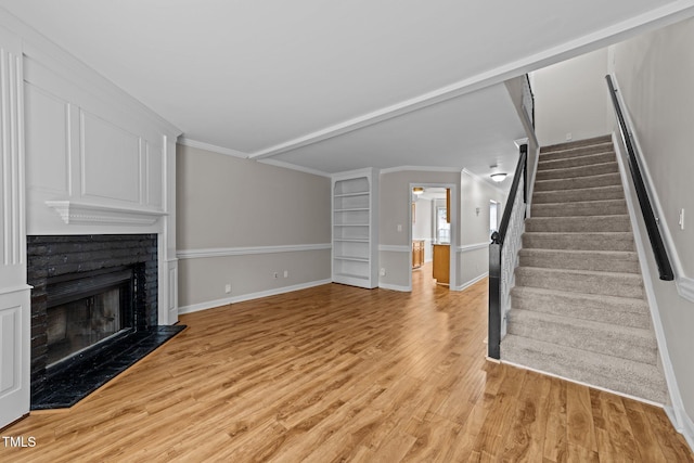 unfurnished living room featuring ornamental molding and light hardwood / wood-style floors