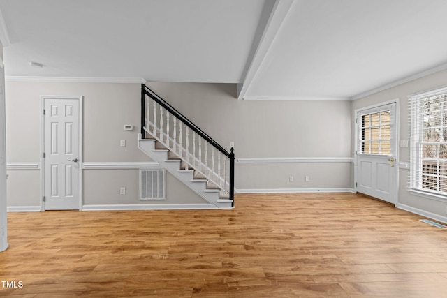 entrance foyer with crown molding, beam ceiling, and light hardwood / wood-style floors