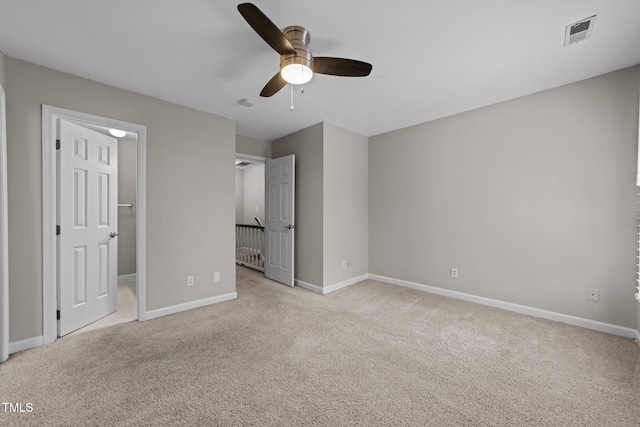 unfurnished bedroom featuring ceiling fan, light colored carpet, and a walk in closet