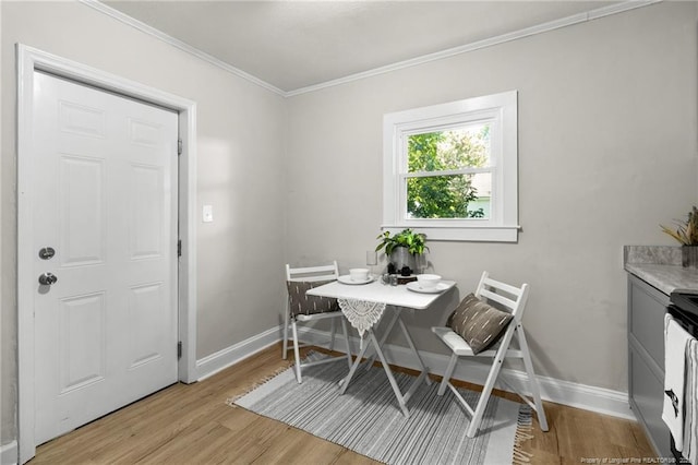 dining space featuring crown molding and light hardwood / wood-style flooring