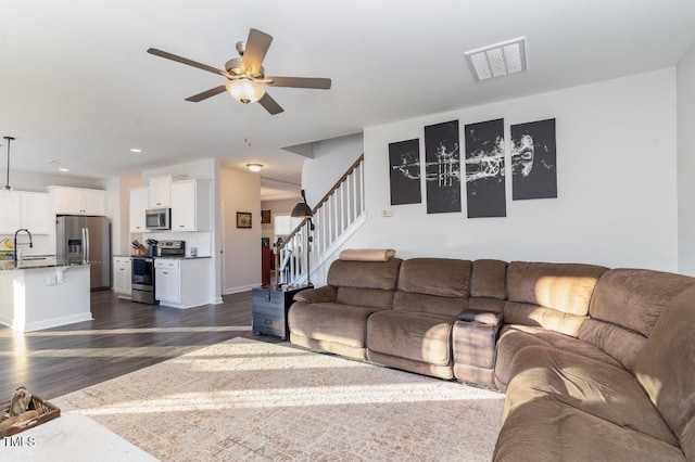 living room with sink, dark hardwood / wood-style floors, and ceiling fan