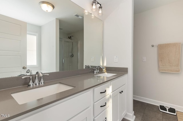 bathroom featuring tile patterned flooring, vanity, and a shower with shower door