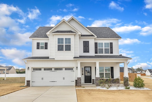 craftsman-style home featuring stone siding, a garage, and fence