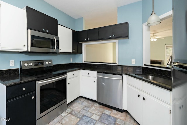 kitchen with hanging light fixtures, white cabinets, and stainless steel appliances