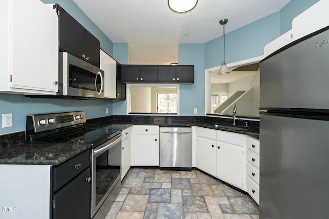 kitchen with sink, white cabinetry, appliances with stainless steel finishes, and hanging light fixtures