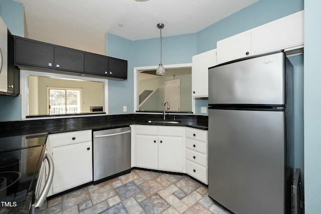 kitchen with white cabinets, decorative light fixtures, appliances with stainless steel finishes, and sink