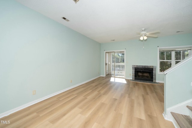 unfurnished living room with ceiling fan, a textured ceiling, light hardwood / wood-style flooring, and a fireplace