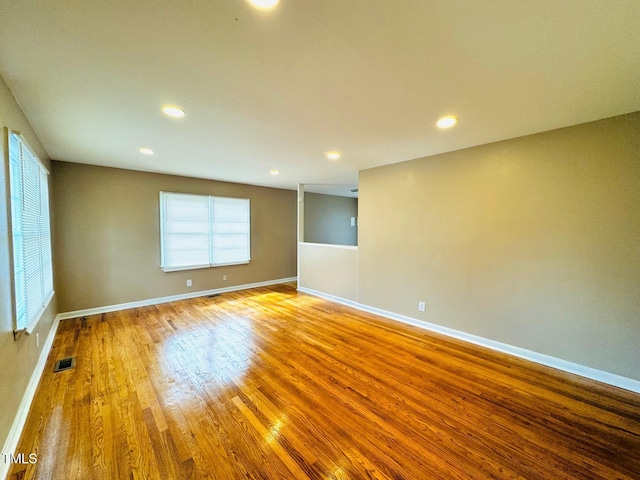 empty room with a wealth of natural light and wood-type flooring