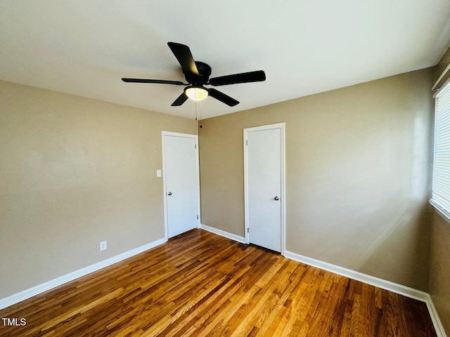 unfurnished bedroom with ceiling fan and wood-type flooring