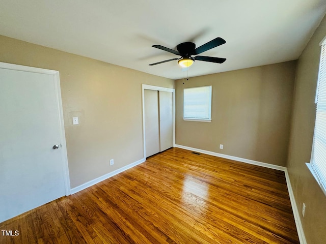 unfurnished bedroom with a closet, ceiling fan, and wood-type flooring