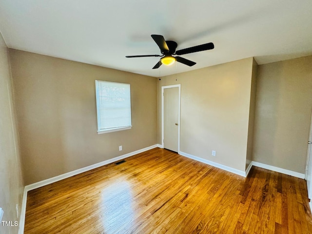 empty room with hardwood / wood-style flooring and ceiling fan