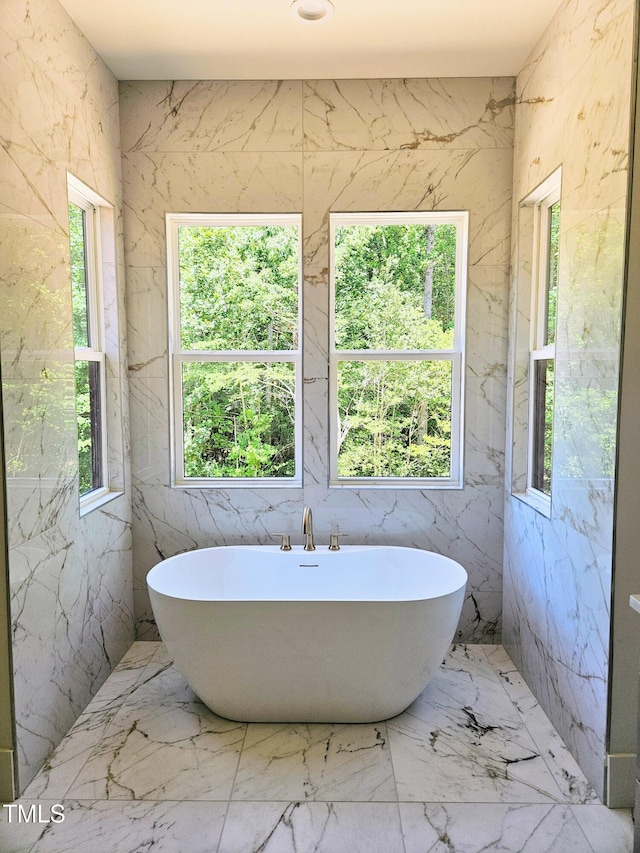 109 Evander Way, Pittsboro, NC 27312 - bathroom featuring healthy amount of natural light, a freestanding tub, and marble tiled floors