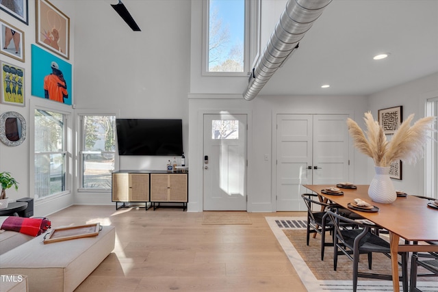 foyer entrance with light wood-type flooring and a high ceiling