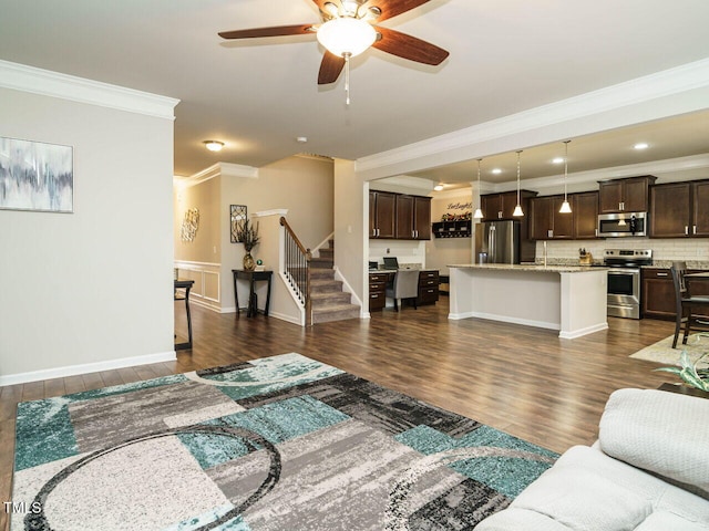 living room featuring dark wood-type flooring, ceiling fan, and ornamental molding