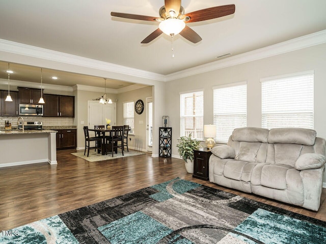 living room featuring crown molding, sink, ceiling fan with notable chandelier, and dark hardwood / wood-style floors