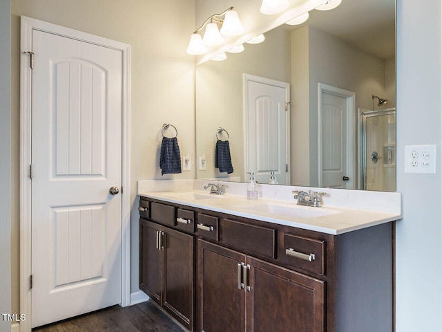 bathroom with a shower with door, hardwood / wood-style flooring, and vanity