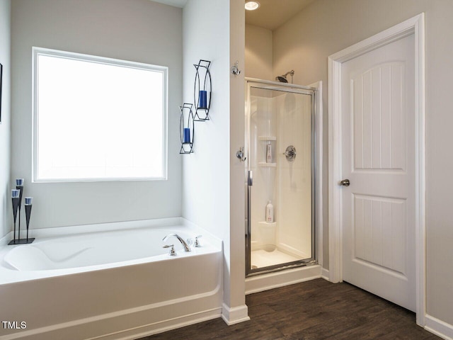 bathroom with hardwood / wood-style flooring, plenty of natural light, and separate shower and tub