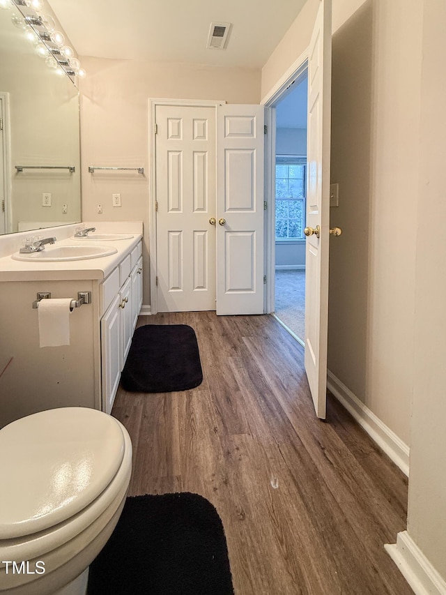 bathroom featuring hardwood / wood-style flooring, vanity, and toilet