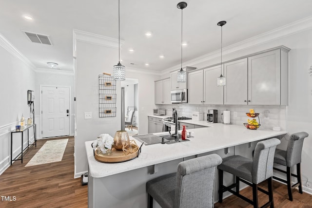 kitchen featuring stainless steel appliances, pendant lighting, a kitchen breakfast bar, and kitchen peninsula