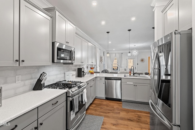 kitchen with stainless steel appliances, decorative light fixtures, sink, and gray cabinetry