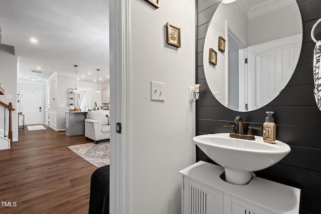 bathroom with crown molding, wood-type flooring, and sink