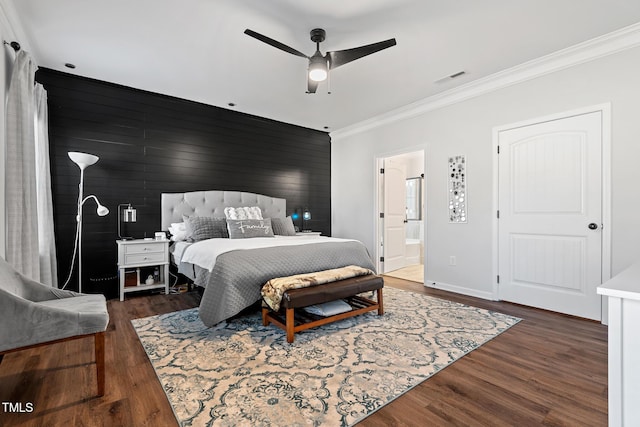 bedroom featuring crown molding, ensuite bath, dark hardwood / wood-style floors, and ceiling fan