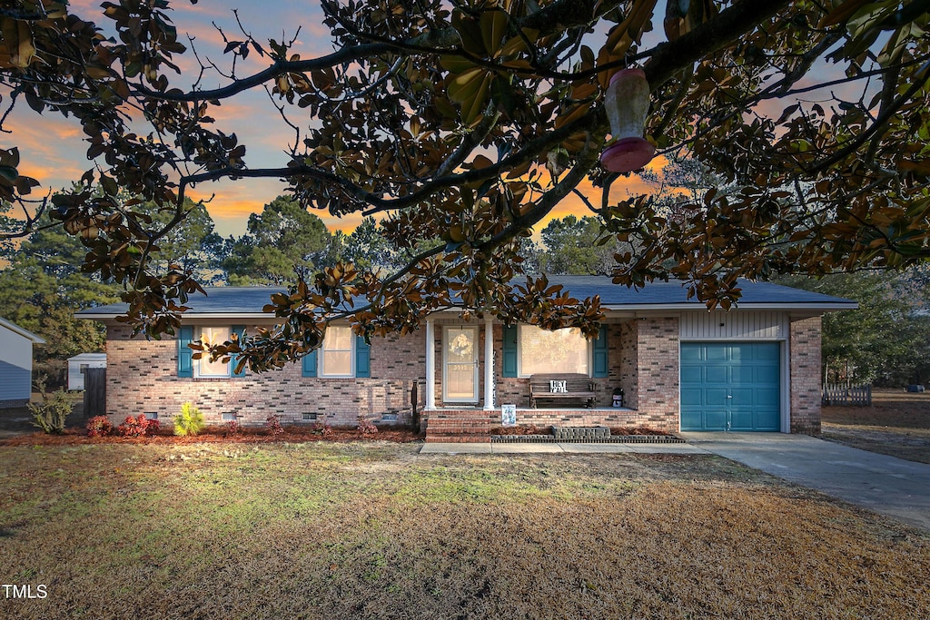 view of front facade featuring a garage and a lawn