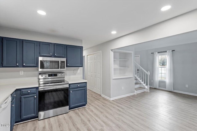 kitchen with built in shelves, stainless steel appliances, blue cabinets, and light hardwood / wood-style flooring