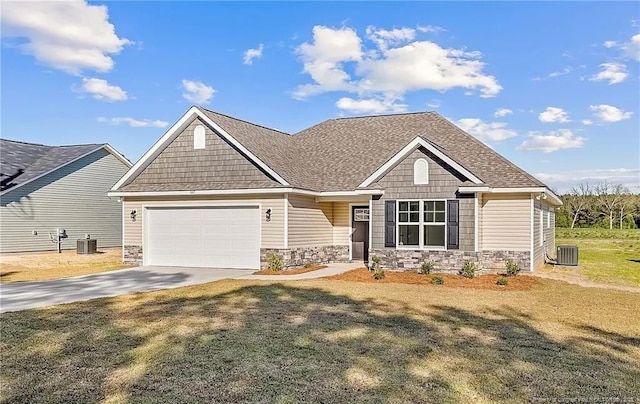 craftsman inspired home featuring cooling unit, a front yard, and a garage