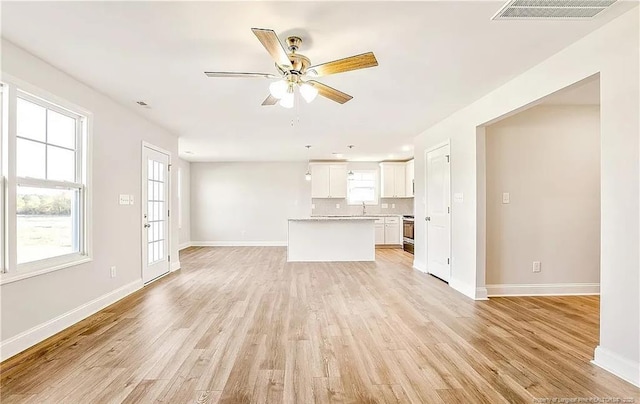 unfurnished living room with ceiling fan, plenty of natural light, light hardwood / wood-style flooring, and sink