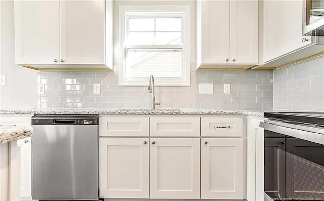 kitchen with light stone counters, white cabinets, tasteful backsplash, and stainless steel appliances