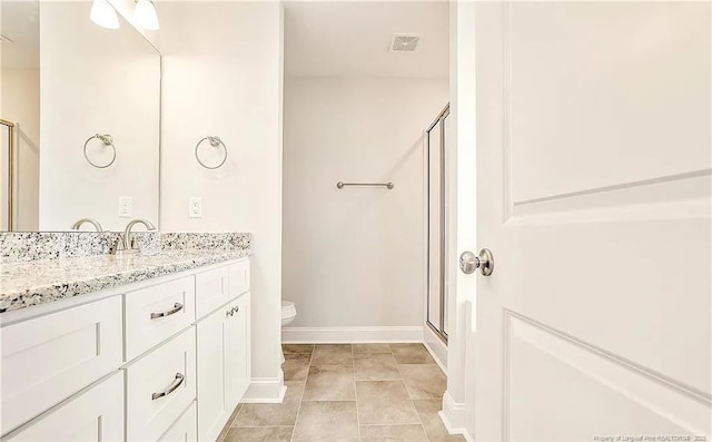 bathroom featuring toilet, walk in shower, vanity, and tile patterned flooring