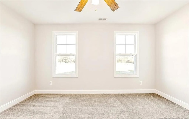 carpeted spare room featuring ceiling fan